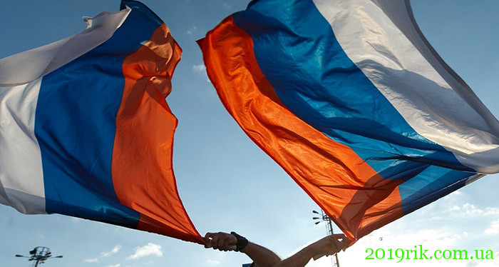 Чоловік тримає флаги Росії